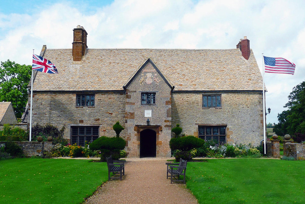 Sulgrave Manor NSCDAOR A brownish brick house with flags on either side